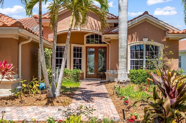 7521 Aralia Way, Seminole, FL 33777 - property entrance featuring french doors, a tiled roof, and stucco siding