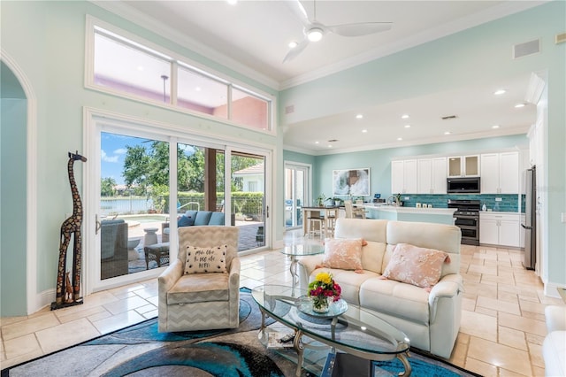 7521 Aralia Way, Seminole, FL 33777 - living room featuring crown molding, ceiling fan, recessed lighting, a high ceiling, and a water view