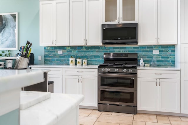 7521 Aralia Way, Seminole, FL 33777 - kitchen with stainless steel range with gas stovetop, light countertops, backsplash, and white cabinets