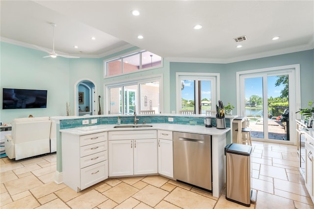 7521 Aralia Way, Seminole, FL 33777 - kitchen featuring stainless steel dishwasher, crown molding, light countertops, open floor plan, and healthy amount of natural light