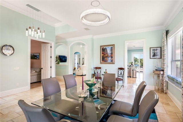 7521 Aralia Way, Seminole, FL 33777 - dining area featuring arched walkways, crown molding, and stone tile flooring