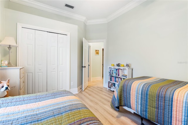 7521 Aralia Way, Seminole, FL 33777 - bedroom with light wood-style floors, ornamental molding, and a closet