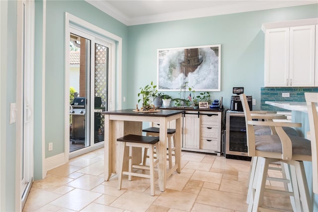 7521 Aralia Way, Seminole, FL 33777 - kitchen with white cabinetry, crown molding, stone tile floors, and tasteful backsplash