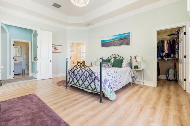 7521 Aralia Way, Seminole, FL 33777 - bedroom with a walk in closet, wood finished floors, crown molding, connected bathroom, and a closet