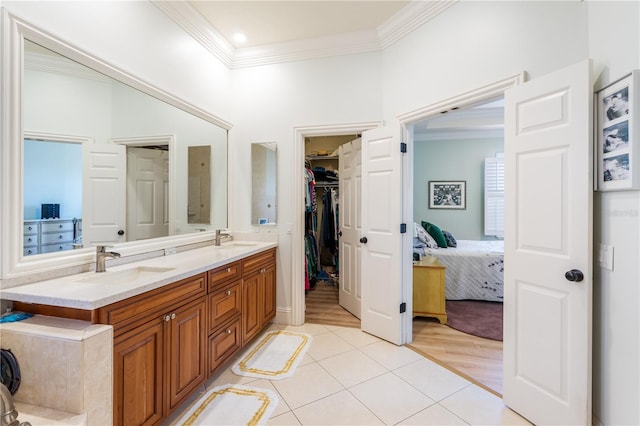 7521 Aralia Way, Seminole, FL 33777 - ensuite bathroom with ornamental molding, double vanity, tile patterned flooring, and a walk in closet