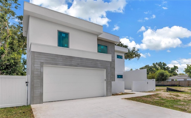 2065 Goldenrod St, Sarasota, FL 34239 - contemporary home featuring a garage, stucco siding, concrete driveway, and a gate