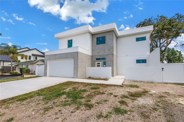 2065 Goldenrod St, Sarasota, FL 34239 - contemporary house featuring a gate, driveway, a garage, and stucco siding
