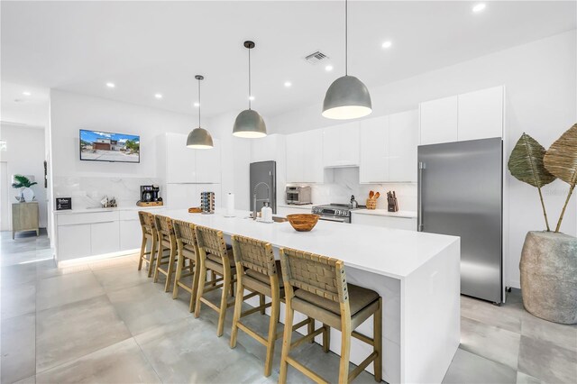 2065 Goldenrod St, Sarasota, FL 34239 - kitchen with appliances with stainless steel finishes, backsplash, recessed lighting, white cabinets, and a large island with sink