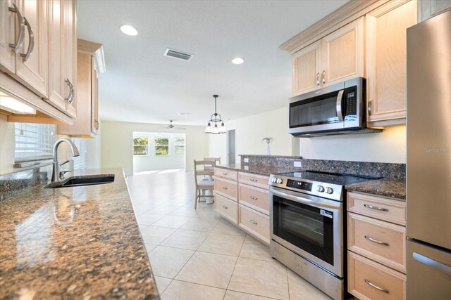 107 Clipper Way Unit 107, Nokomis, FL 34275 - kitchen with stainless steel appliances, light brown cabinets, recessed lighting, light tile patterned floors, and dark stone countertops