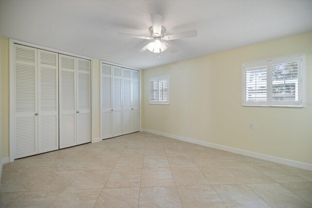 107 Clipper Way Unit 107, Nokomis, FL 34275 - unfurnished bedroom featuring multiple closets and ceiling fan
