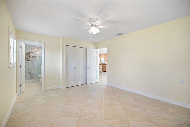 107 Clipper Way Unit 107, Nokomis, FL 34275 - unfurnished bedroom with ensuite bath, a ceiling fan, a closet, and light tile patterned floors