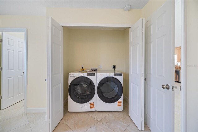 107 Clipper Way Unit 107, Nokomis, FL 34275 - washroom with light tile patterned floors and washing machine and clothes dryer