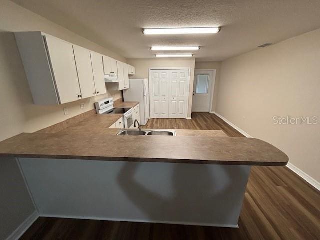 888 W Stuart St, Bartow, FL 33830 - kitchen featuring white appliances, a peninsula, dark wood-type flooring, white cabinets, and range hood