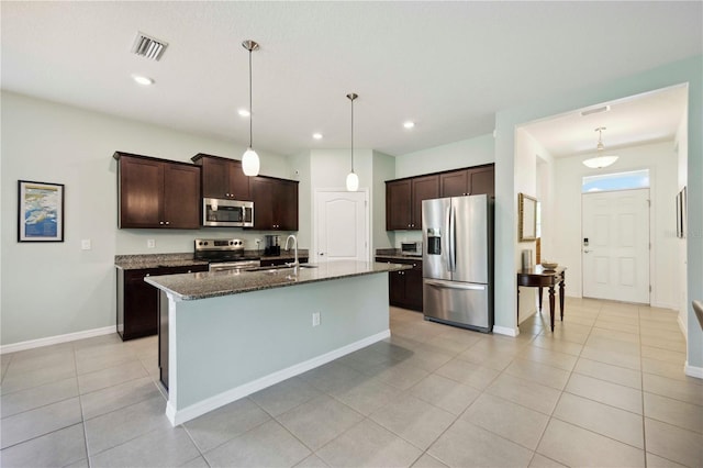 13804 Woodbridge Ter, Lakewood Ranch, FL 34211 - kitchen featuring stainless steel appliances, dark brown cabinets, dark stone counters, light tile patterned floors, and recessed lighting