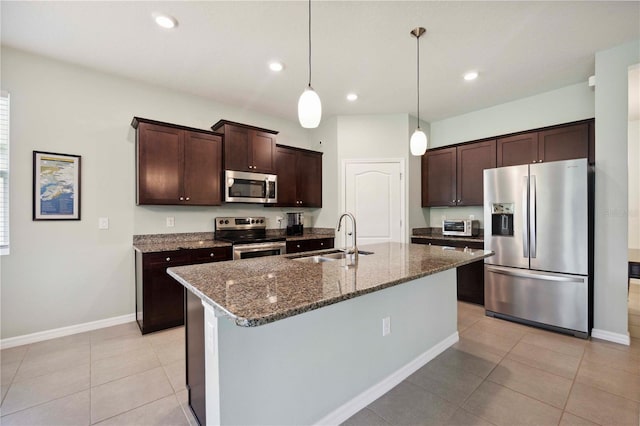 13804 Woodbridge Ter, Lakewood Ranch, FL 34211 - kitchen with appliances with stainless steel finishes, dark brown cabinets, dark stone counters, light tile patterned flooring, and recessed lighting