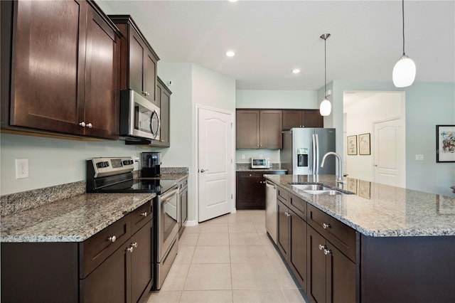 13804 Woodbridge Ter, Lakewood Ranch, FL 34211 - kitchen featuring appliances with stainless steel finishes, dark brown cabinetry, light tile patterned flooring, an island with sink, and recessed lighting