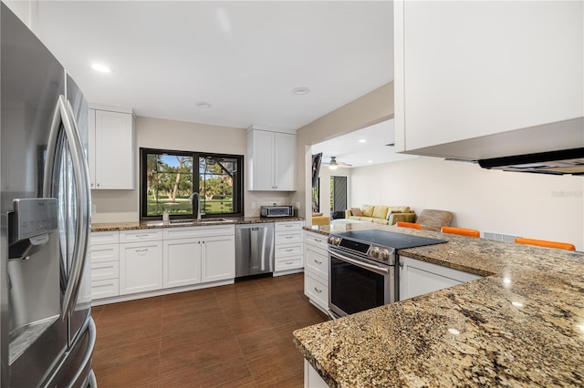 3658 Torrey Pines Way, Sarasota, FL 34238 - kitchen with appliances with stainless steel finishes, dark stone countertops, white cabinetry, and recessed lighting