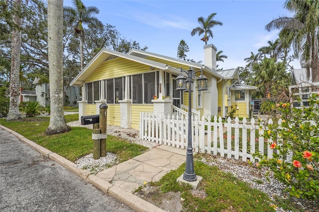 403 29th St NW, Bradenton, FL 34205 - view of front of property featuring a sunroom, a chimney, a standing seam roof, and a metal roof
