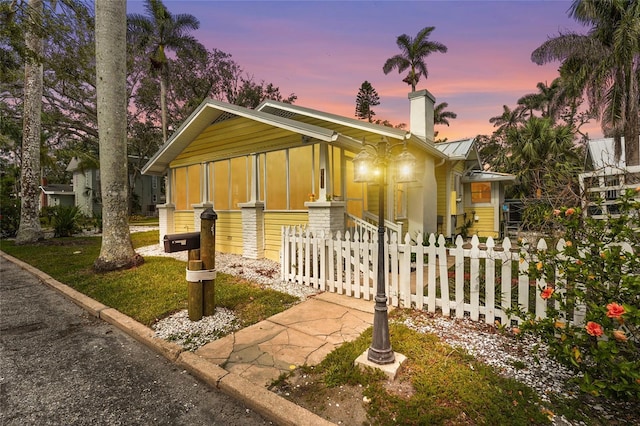 403 29th St NW, Bradenton, FL 34205 - view of front of house featuring a chimney, a fenced front yard, a metal roof, a standing seam roof, and board and batten siding