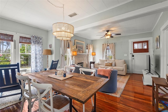 403 29th St NW, Bradenton, FL 34205 - dining room featuring plenty of natural light, dark wood finished floors, a brick fireplace, a ceiling fan, and crown molding
