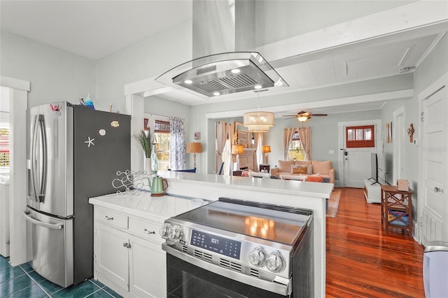 403 29th St NW, Bradenton, FL 34205 - kitchen featuring island range hood, appliances with stainless steel finishes, a peninsula, a ceiling fan, and white cabinetry