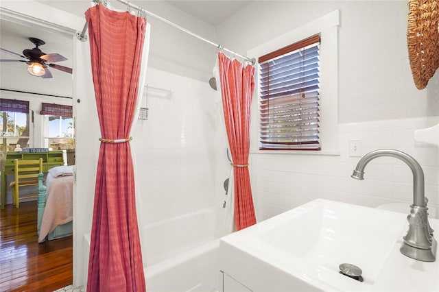 403 29th St NW, Bradenton, FL 34205 - bathroom featuring tile walls, shower / bath combo, ceiling fan, wood finished floors, and wainscoting