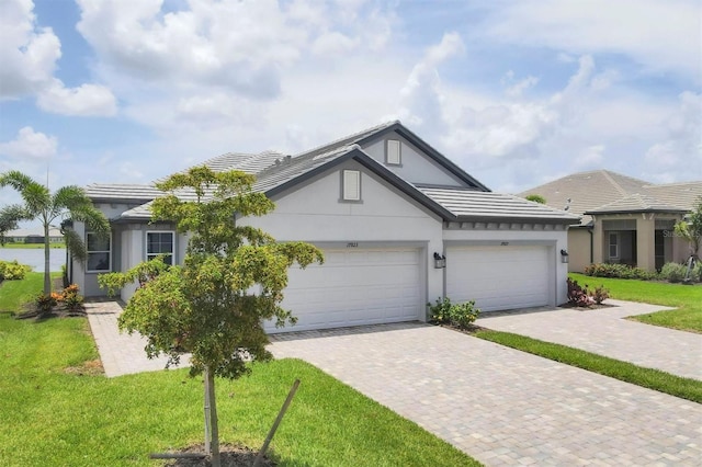 17823 Cherished Loop, Bradenton, FL 34211 - view of front of property with stucco siding, decorative driveway, a front yard, a garage, and a tile roof