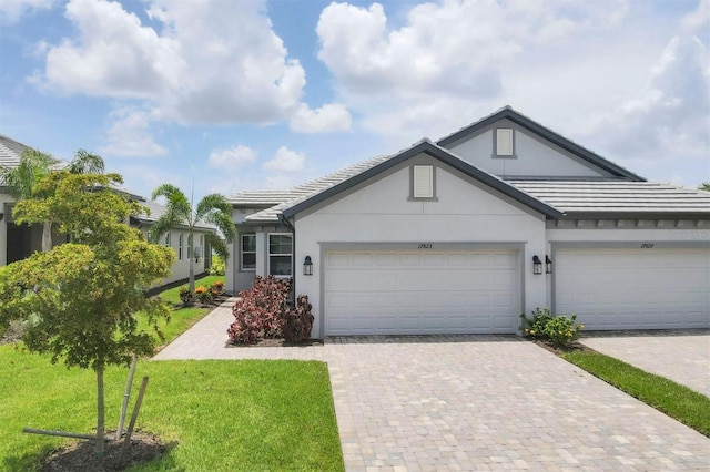 17823 Cherished Loop, Bradenton, FL 34211 - single story home with stucco siding, decorative driveway, a front yard, a tiled roof, and a garage