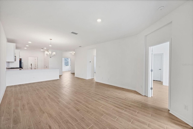 17823 Cherished Loop, Bradenton, FL 34211 - unfurnished living room featuring a chandelier, light wood-style flooring, and recessed lighting