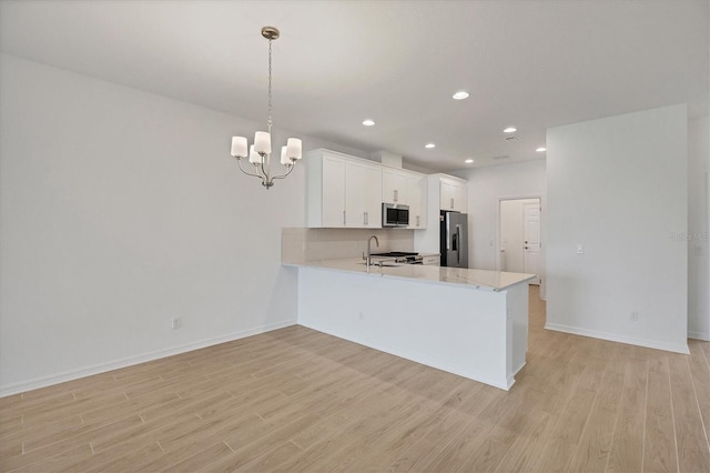 17823 Cherished Loop, Bradenton, FL 34211 - kitchen with appliances with stainless steel finishes, light wood-type flooring, a chandelier, a peninsula, and white cabinetry