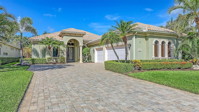 8832 Enclave Ct, Sarasota, FL 34238 - mediterranean / spanish-style home featuring a tiled roof, stucco siding, an attached garage, and decorative driveway