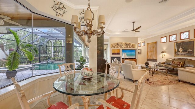 8832 Enclave Ct, Sarasota, FL 34238 - dining space featuring ornamental molding, a ceiling fan, light tile patterned floors, a tray ceiling, and a sunroom