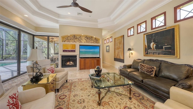 8832 Enclave Ct, Sarasota, FL 34238 - living area with ornamental molding, a ceiling fan, a raised ceiling, a glass covered fireplace, and recessed lighting