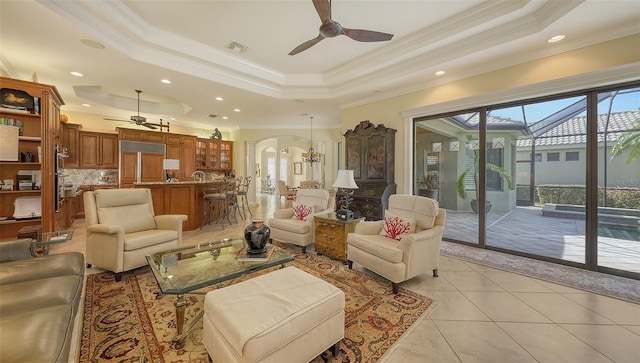 8832 Enclave Ct, Sarasota, FL 34238 - living room featuring ceiling fan, arched walkways, ornamental molding, a tray ceiling, and light tile patterned floors