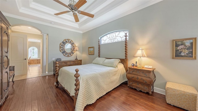 8832 Enclave Ct, Sarasota, FL 34238 - bedroom with a raised ceiling, arched walkways, decorative columns, hardwood / wood-style floors, and crown molding