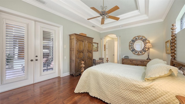8832 Enclave Ct, Sarasota, FL 34238 - bedroom featuring access to exterior, a tray ceiling, arched walkways, dark wood finished floors, and ornate columns
