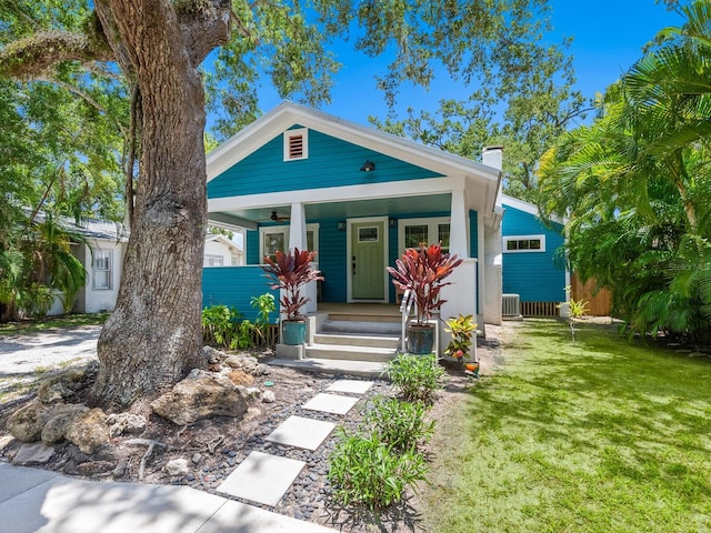1732 6th St, Sarasota, FL 34236 - shotgun-style home with a chimney, covered porch, and a front lawn