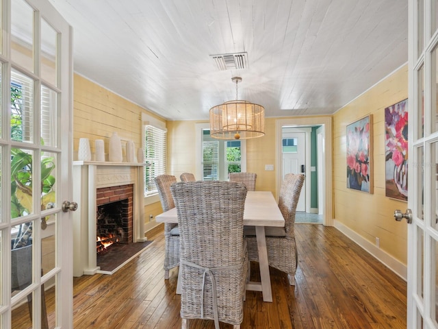 1732 6th St, Sarasota, FL 34236 - dining area with dark wood finished floors, a chandelier, french doors, a brick fireplace, and wooden ceiling
