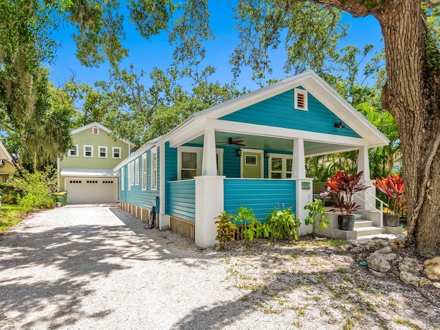 1732 6th St, Sarasota, FL 34236 - shotgun-style home with covered porch, an outdoor structure, ceiling fan, gravel driveway, and a garage