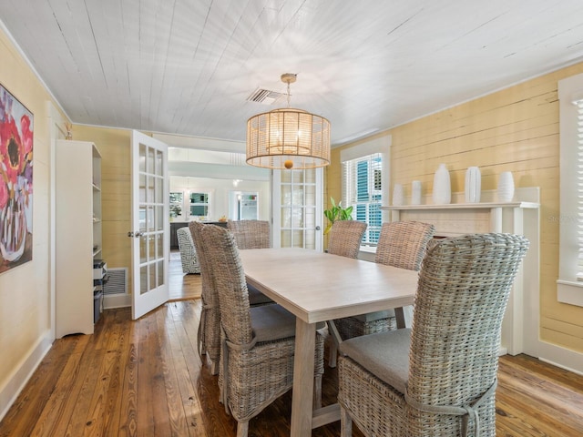 1732 6th St, Sarasota, FL 34236 - dining area with hardwood / wood-style floors, french doors, wooden walls, and a chandelier