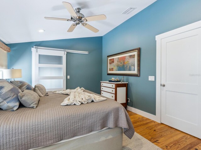 1732 6th St, Sarasota, FL 34236 - bedroom with a barn door, wood finished floors, lofted ceiling, and ceiling fan
