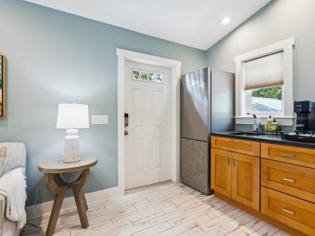 1732 6th St, Sarasota, FL 34236 - kitchen featuring freestanding refrigerator, brown cabinetry, light wood finished floors, dark countertops, and recessed lighting