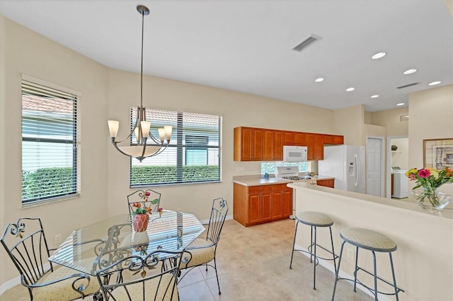 5179 Cantabria Crst, Sarasota, FL 34238 - kitchen featuring white appliances, a kitchen breakfast bar, healthy amount of natural light, light countertops, and recessed lighting