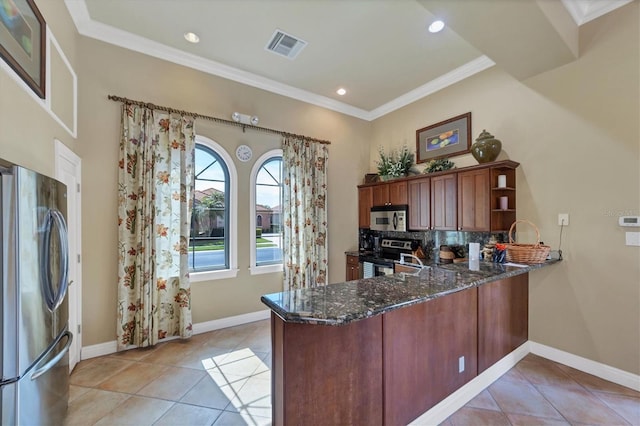 5179 Cantabria Crst, Sarasota, FL 34238 - kitchen with stainless steel appliances, dark stone counters, a peninsula, decorative backsplash, and crown molding