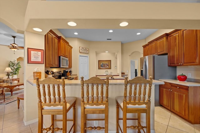 11508 30th Cv E, Parrish, FL 34219 - kitchen with appliances with stainless steel finishes, light tile patterned flooring, a breakfast bar area, and recessed lighting