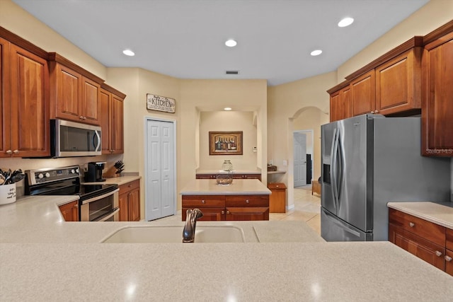 11508 30th Cv E, Parrish, FL 34219 - kitchen featuring stainless steel appliances, light countertops, recessed lighting, light tile patterned flooring, and arched walkways