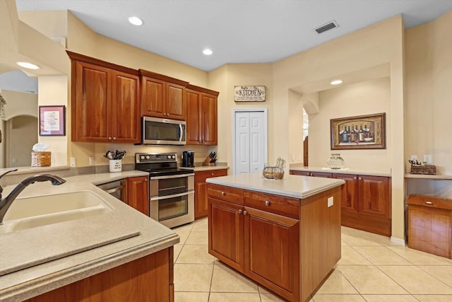 11508 30th Cv E, Parrish, FL 34219 - kitchen featuring appliances with stainless steel finishes, light tile patterned floors, light countertops, arched walkways, and recessed lighting