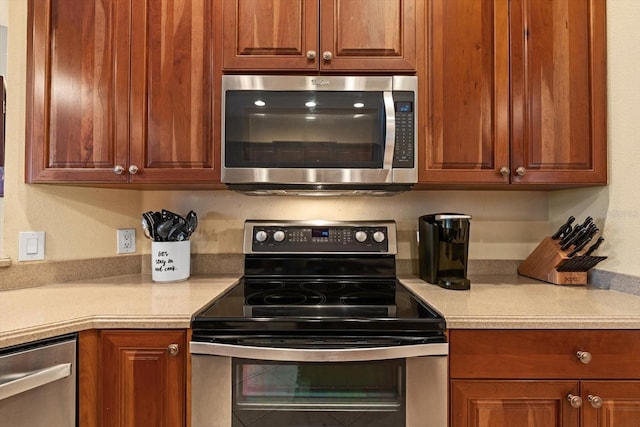 11508 30th Cv E, Parrish, FL 34219 - kitchen featuring appliances with stainless steel finishes, light countertops, and brown cabinetry