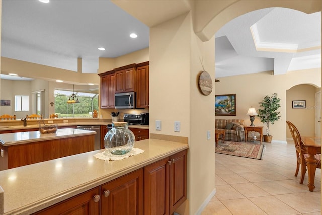 11508 30th Cv E, Parrish, FL 34219 - kitchen featuring appliances with stainless steel finishes, a peninsula, arched walkways, light countertops, and light tile patterned floors