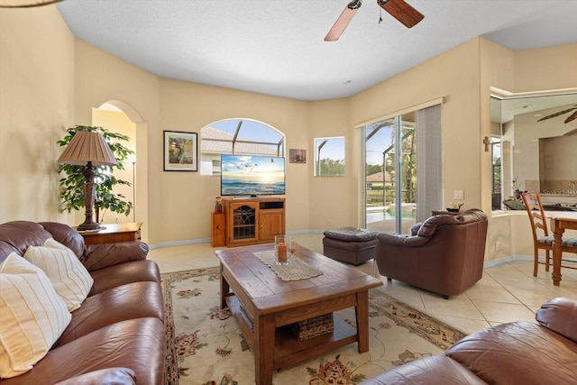 11508 30th Cv E, Parrish, FL 34219 - living room featuring healthy amount of natural light, a ceiling fan, light tile patterned flooring, and arched walkways